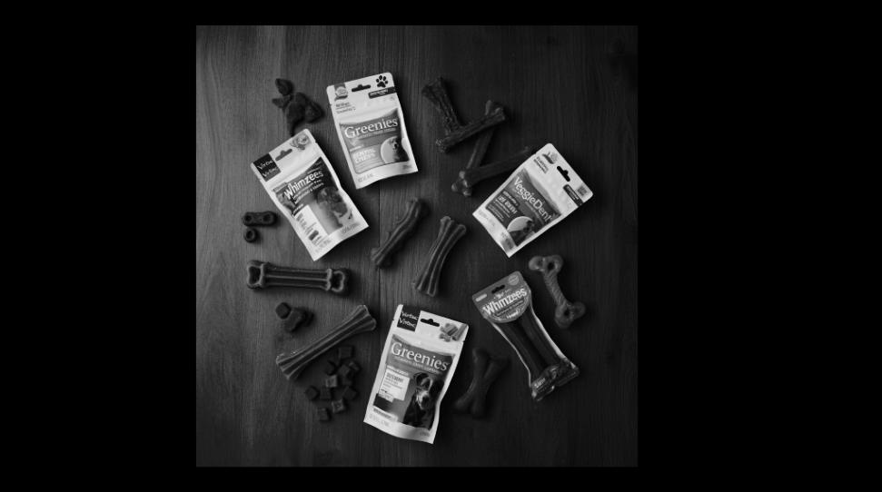 Various dental chews for dogs displayed on a wooden table